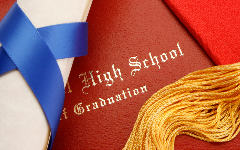 closeup of diploma and leatherette folder with words "High School Graduation"